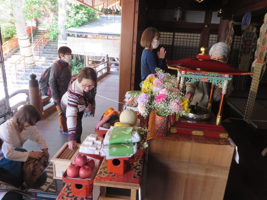 参拝の方々が甘茶を灌ぎ