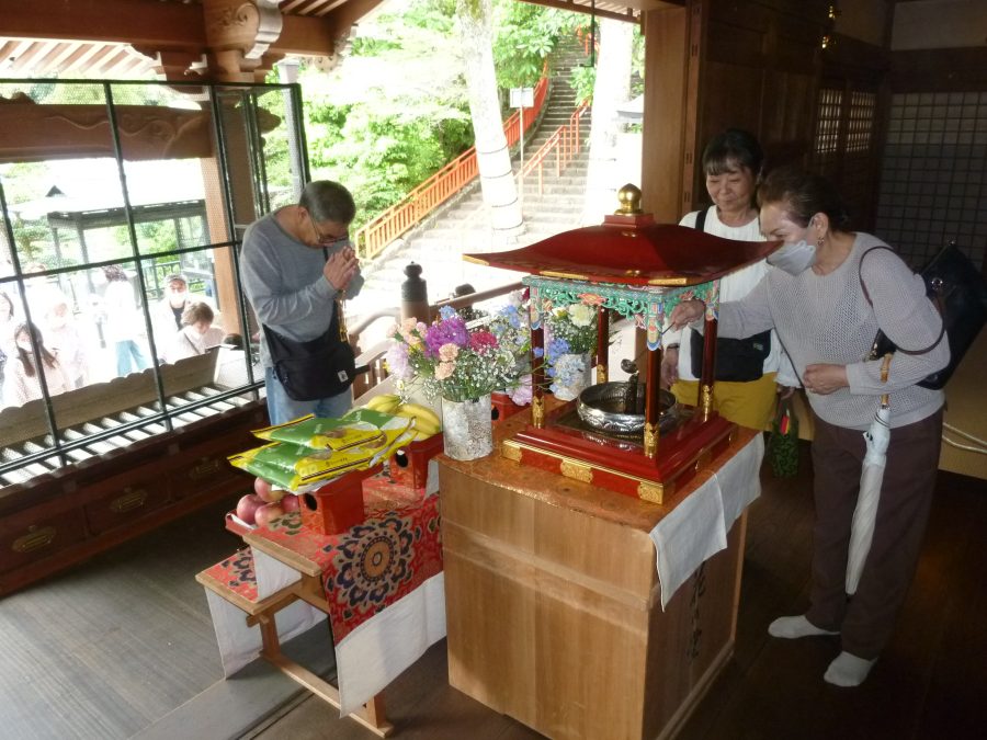 参拝の方々が甘茶を灌ぎ